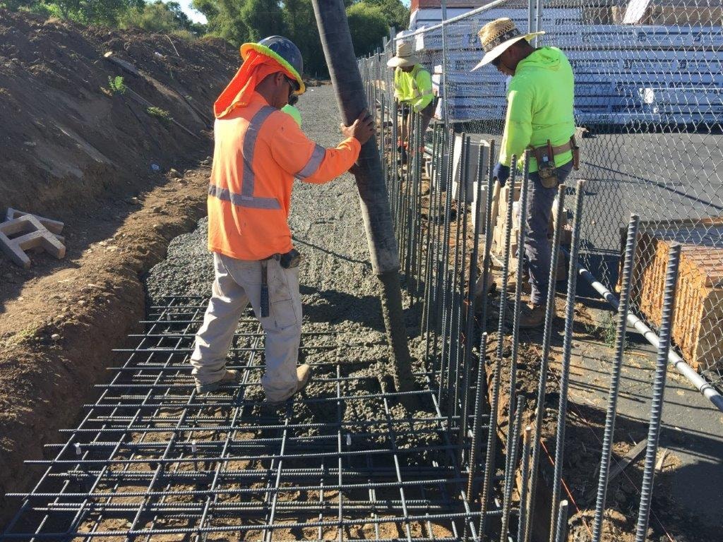 Crew placing rebar grid for concrete foundation wall