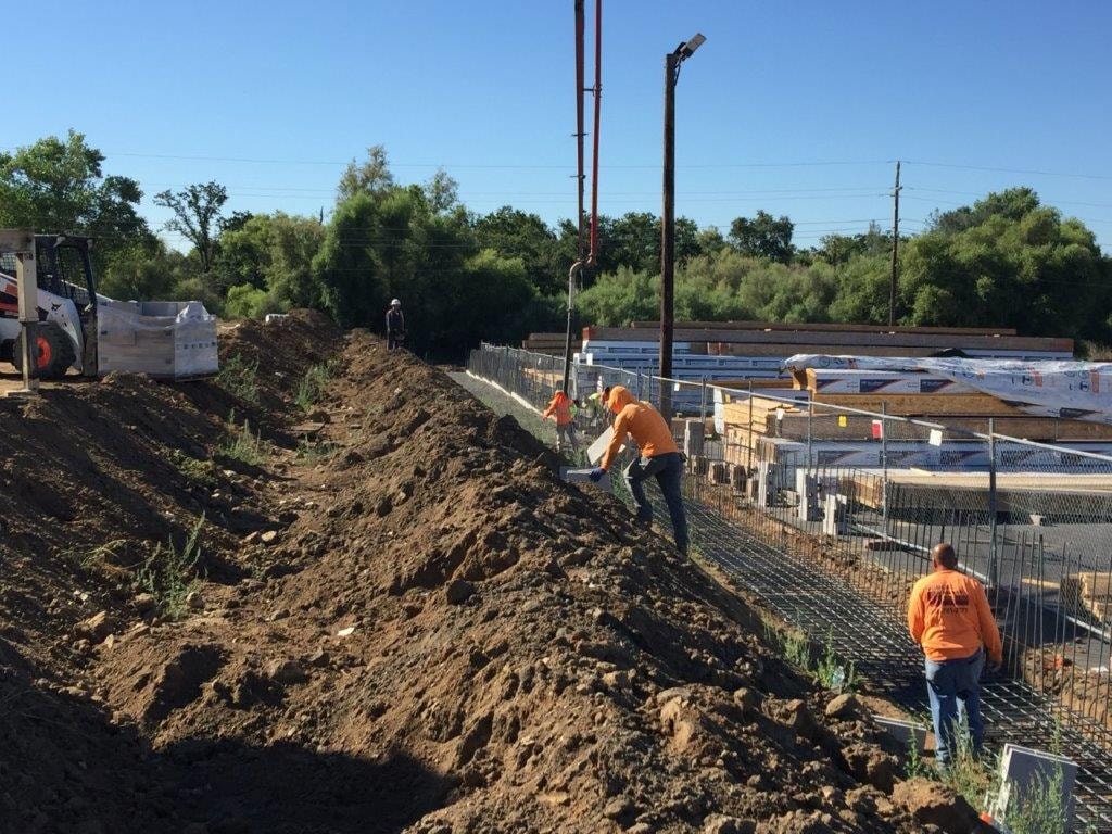NorCal Masonry crew placing block along foundation trench